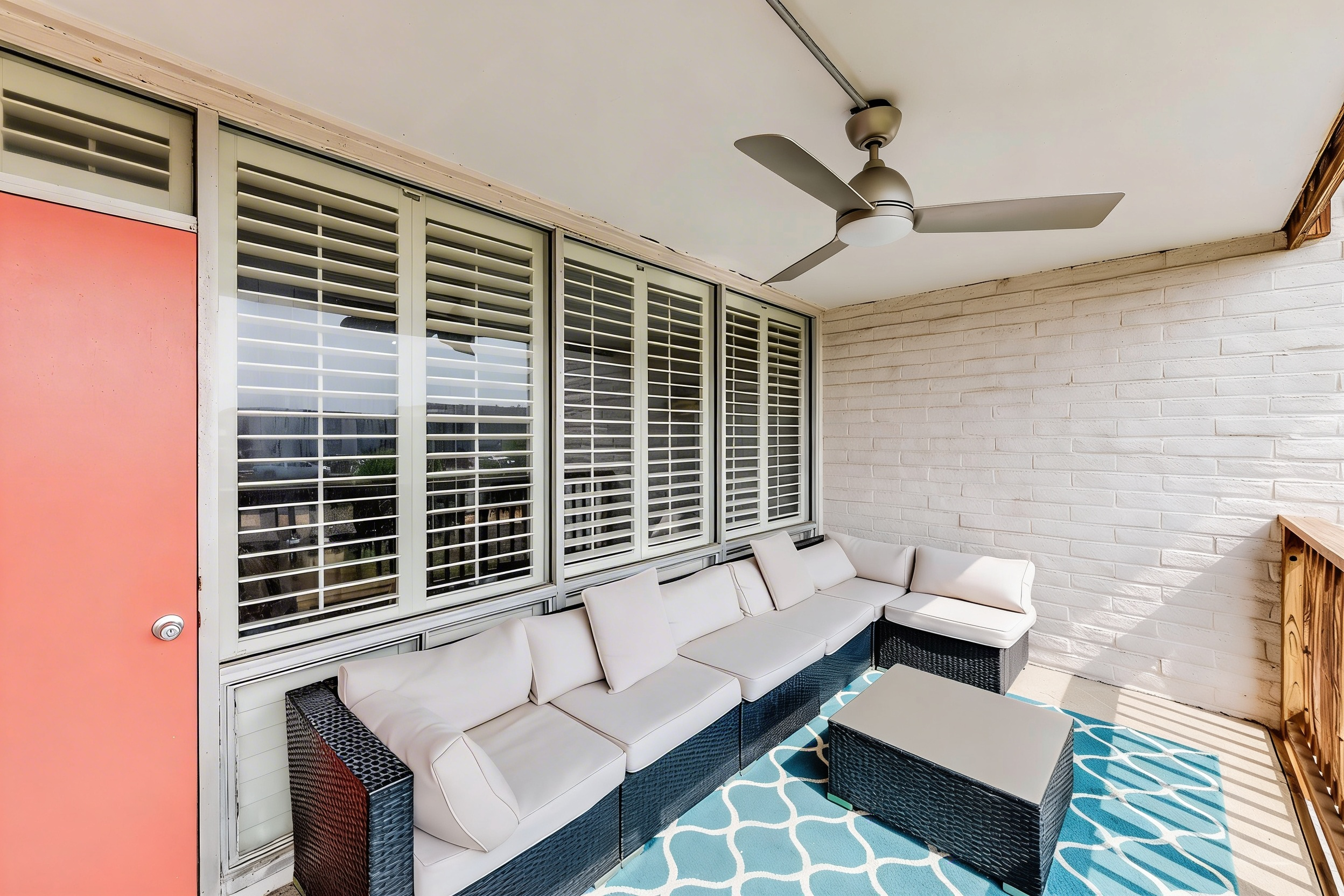 Covered balcony with sectional seating and rug extending living space in Port Aransas condo